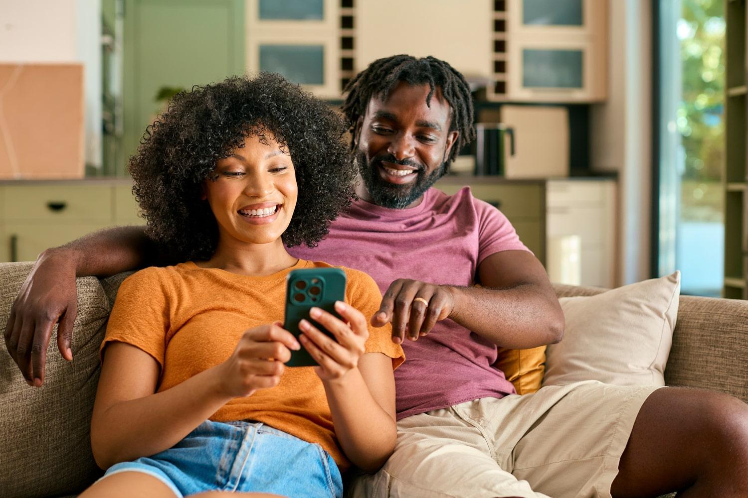 Couple souriant consultant leur assurance sur smartphone